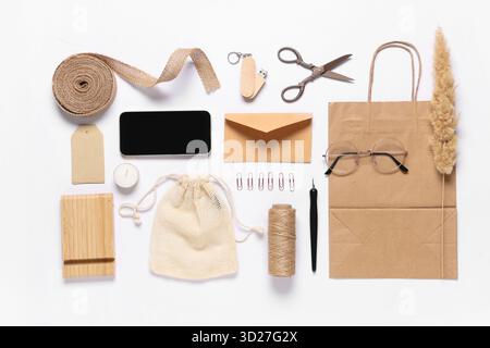 Composition with mobile phone, packaging items and delivery paper bag on white background Stock Photo
