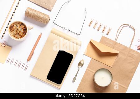 Composition with mobile phone, packaging items and delivery paper bag on white background Stock Photo