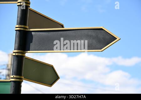 A street sign with a black arrow pointing to the right. The sign is surrounded by a green and gold frame Stock Photo