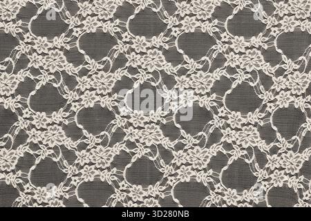 Delicate floral lace fabric pattern on black background, ideal as an overlay or decorative background for design projects Stock Photo