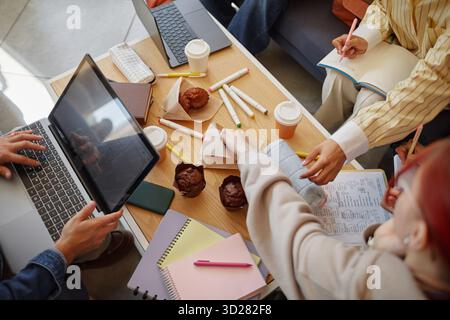 Diverse Young Adults Collaborating on Project Around Table with Laptops Stock Photo