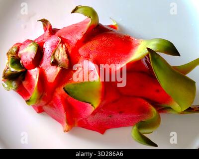 Red dragon fruit on a white plate. Stock Photo