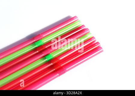Collection of green, pink and red plastic straws against a white background Stock Photo