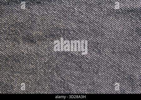 Close-up of a weave pattern on gray grey denim fabric abstract textured background Stock Photo