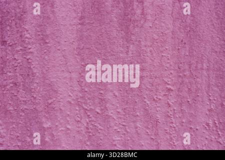 Uneven rough dark pink plaster on the wall. Stock Photo
