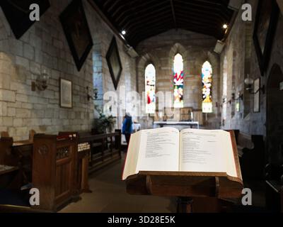 Open Bible on a lectern at the sanctuary in the christian church of Mary the Virgin on Holy Island (Lindisfarne), England. Stock Photo