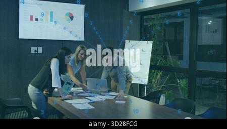 Three professionals reviewing sales data in conference room, with laptop and display screen Stock Photo