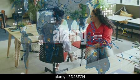 Collaborating colleagues discussing project at office, with wooden table and digital map overlay Stock Photo