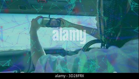 Woman using smartphone checking reflection in cabin, sun visor mirror, steering wheel, copy space Stock Photo