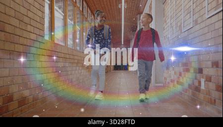 Walking two classmates carrying backpacks inside school hallway, with digital rainbow arc overlay Stock Photo