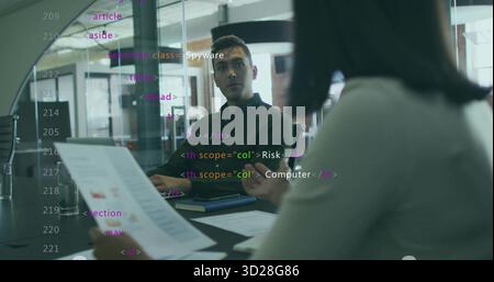 Analyzing printed report, analyst and lead collaborating in meeting room, with laptop, HTML overlay Stock Photo