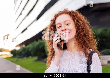 young woman smiling while talking on cell phone Stock Photo