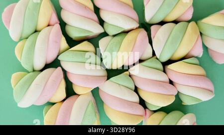 Colorful marshmallows on green background Stock Photo