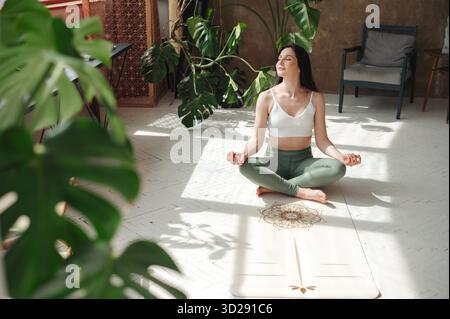 Charming lady performing padmasana exercise with closed eyes Stock Photo