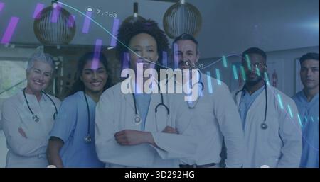 Posing medical team wearing stethoscopes, lab coats and scrubs in hospital lobby, with data overlay Stock Photo