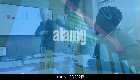 Three professionals in formal attire collaborating around table in meeting room, with chart display Stock Photo