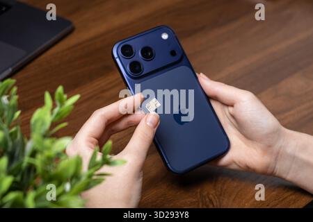 Poznan, Poland - October 16, 2025: iPhone 17 Pro new Apple mobile device with SIM card insertion for essential communication, seamless connectivity in Stock Photo