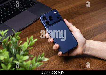 Poznan, Poland - October 16, 2025: iPhone 17 Pro, a blue smartphone with triple camera, is held by hand, representing modern digital lifestyle Stock Photo