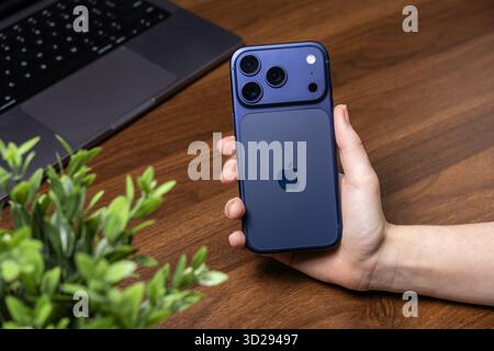Poznan, Poland - October 16, 2025: iPhone 17 Pro, blue smartphone held by hand, emphasizing advanced features for photography, communication, and digi Stock Photo