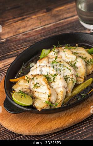 Grilled sea bass fillet served on skillet with vegetables Stock Photo