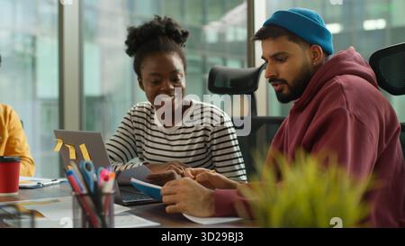 Multi-Ethnic entrepreneurs of informal business startup in office meeting diverse team work process in company workgroup, African American woman talk Stock Photo