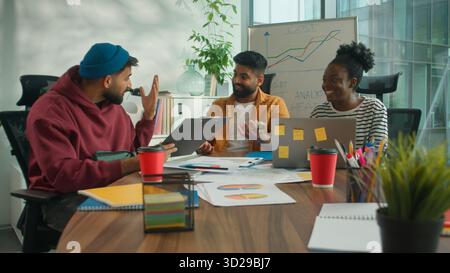 Three business informal diversity workers in meeting office happy success achieve data talking smiling African businesswoman with Hindu men Indian Stock Photo