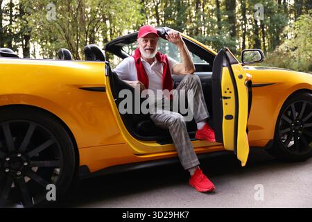 Stylish senior man in modern cabriolet outdoors Stock Photo