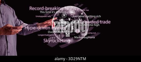 A man pointing at a glowing bubble filled with global banking, gold, cryptocurrency, and stock icons, representing an overheated economy, and the risk Stock Photo