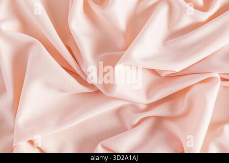 Beautiful abstract peach color background of soft factory fabric. Abstract background. Layout for design. Color of the Year 2024 Peach Fuzz Stock Photo