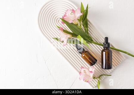Rejuvenating serum for the face, an organic natural remedy in two glass bottles on a white podium in the form of an arch. Top view. A copy space Stock Photo