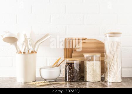 Various kitchen utensils on a marble countertop in a modern kitchen. the concept of decor against the background of a white brick wall Stock Photo