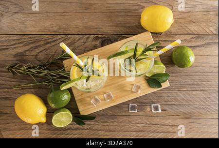 Summer cold drinks with sliced citrus and sparkling water in two glasses on a wooden table. top view. rustic style Stock Photo