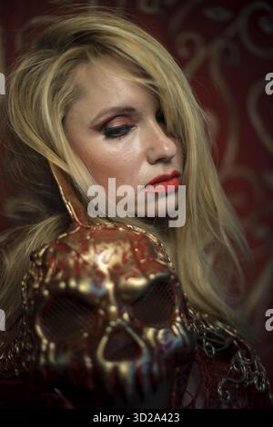 Skull. blonde dressed in red armor gold on red art nouveau flourishes Stock Photo