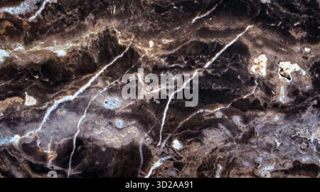 Dark brown marble texture with white natural veins. Polished stone surface showing organic patterns and elegant contrast, perfect for backgrounds Stock Photo