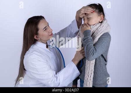 A doctor is checking a sick child's temperature by placing a hand on their head Stock Photo