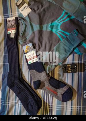 London, City, England, Pair of socks and a sweater are on a bed. The socks are blue and gray and the sweater is gray and blue Stock Photo