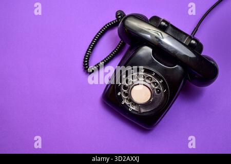 A modern workspace featuring a laptop, smartphone, and a tablet A classic landline telephone Stock Photo