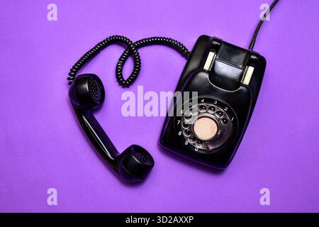 A modern workspace featuring a laptop, smartphone, and a tablet A classic landline telephone Stock Photo