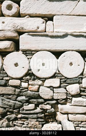 Wall built with square and round marble stones from temples and old buildings in the old town of Parikia, Paros, Athens Stock Photo