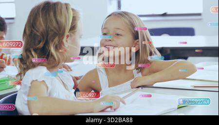 Leaning together, two child students sharing notes at classroom desks with notebooks, textbooks Stock Photo