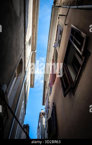 Cres, Croatia-July 28h, 2024: Old houses in the town of Cres, built very close to each other to protect from the strong winds and clothes left to dry Stock Photo