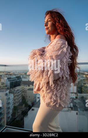Woman on glass terrace at sunset in Mellieha with sea horizon Stock Photo