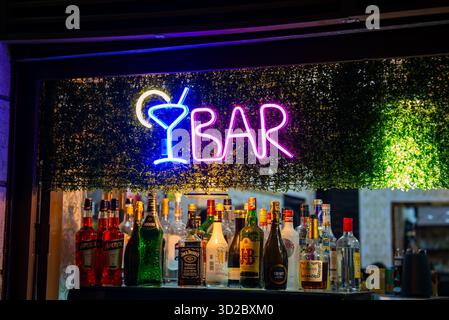 Neon BAR sign with martini icon above liquor shelf in Valletta bar Stock Photo