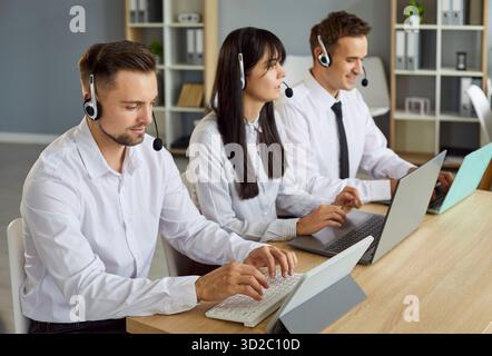 Smiling call center operators providing reliable customer support in office Stock Photo