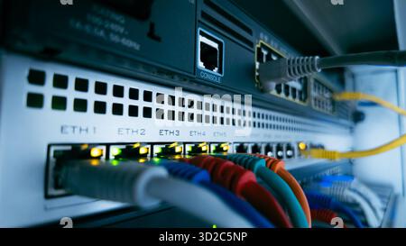 Network cables and glowing lights on professional data switch, representing information flow, digital connectivity, and secure technology infrastructu Stock Photo