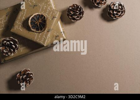 Christmas gifts wrapping with golden paper, ornaments and pine tree cones for a festive celebration. Blank copy space, mockup, template Stock Photo