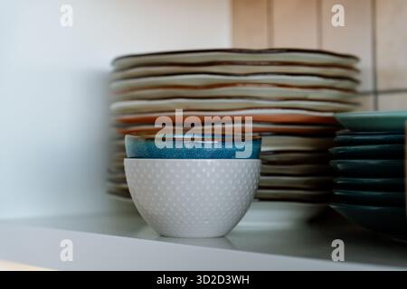 Dishes on the shelf, a stack of clean plates and bowls. Stock Photo