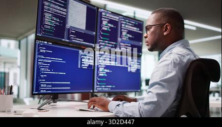Leading African American Engineer Codes Software On Multiple Screens At Office Stock Photo