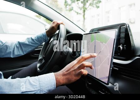 Driving Instructor Teaches Student How To Use Tablet For Navigation. Stock Photo