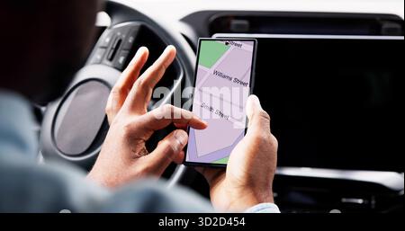 The African American Man Uses His Smartphone To Navigate His Auto. Stock Photo